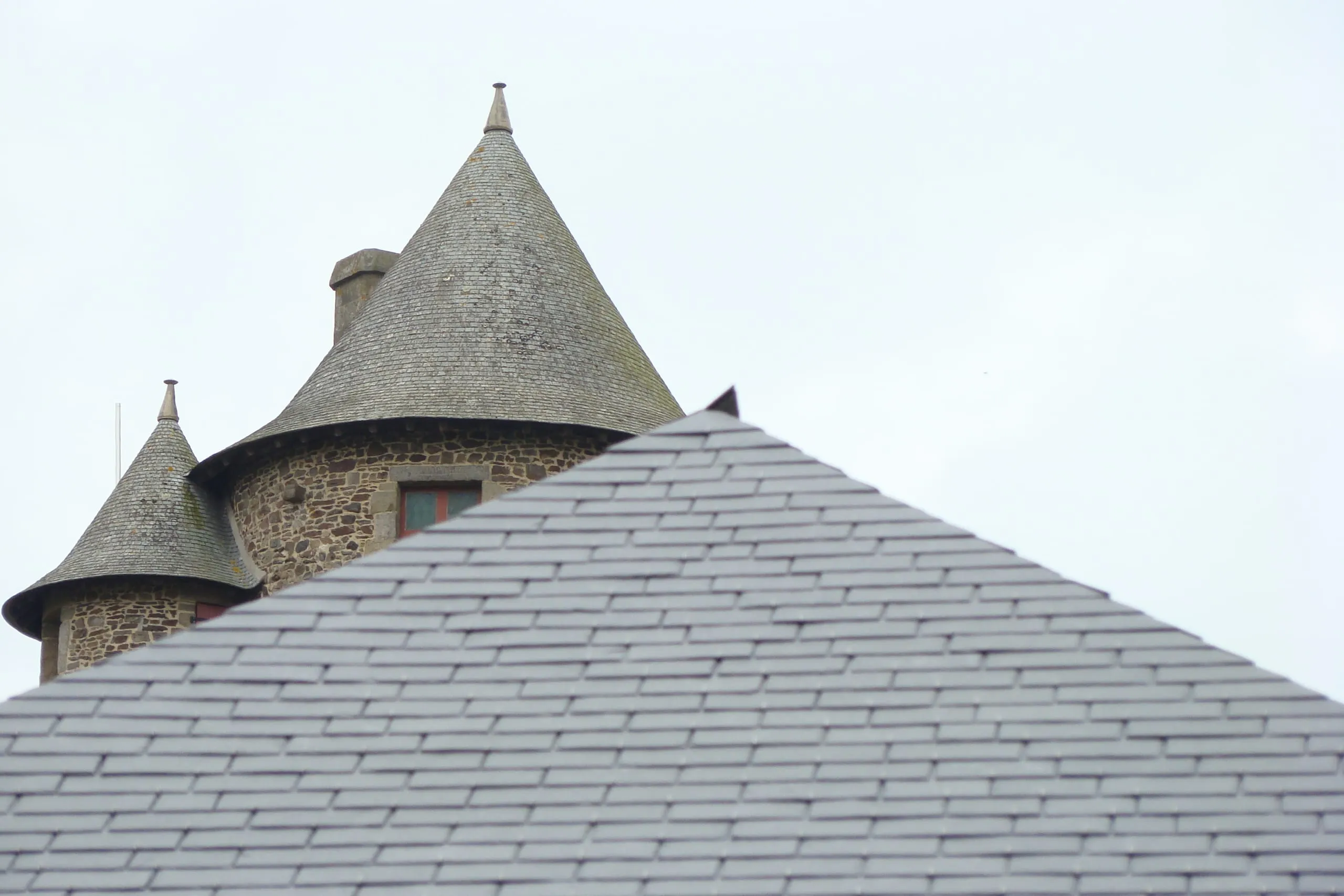 Toitures coniques en ardoise d'un bâtiment patrimonial en pierre