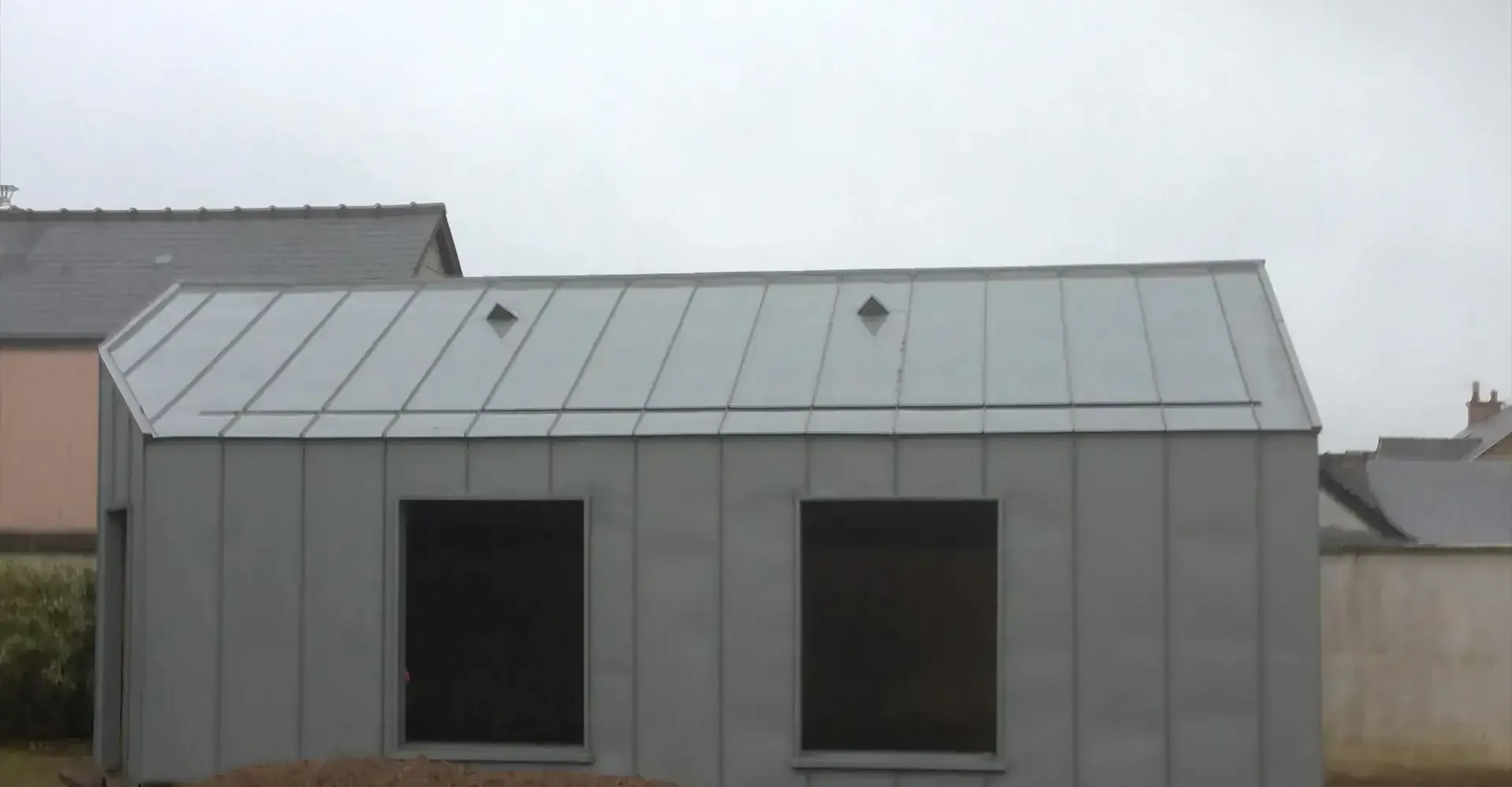 Couverture en zinc et bardage métallique sur une extension de maison