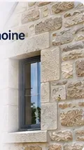 Fenêtre encadrée de pierre de taille sur une façade ancienne